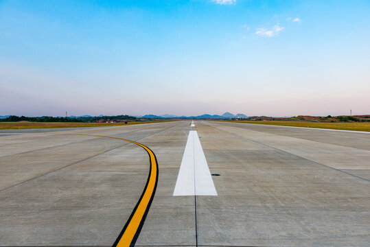 Runway, airstrip in the airport terminal with marking on blue sky with clouds background. Travel aviation concept.