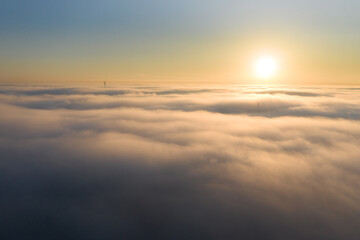 Sonnenaufgang über einer Nebelbank mit Spitzen von Gebäuden