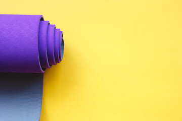 Bright purple yoga mat on a yellow background