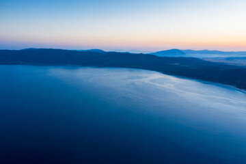 An aerial view of a Salda lake with sunrise and silhouette hill background. Travel Tourism concept.