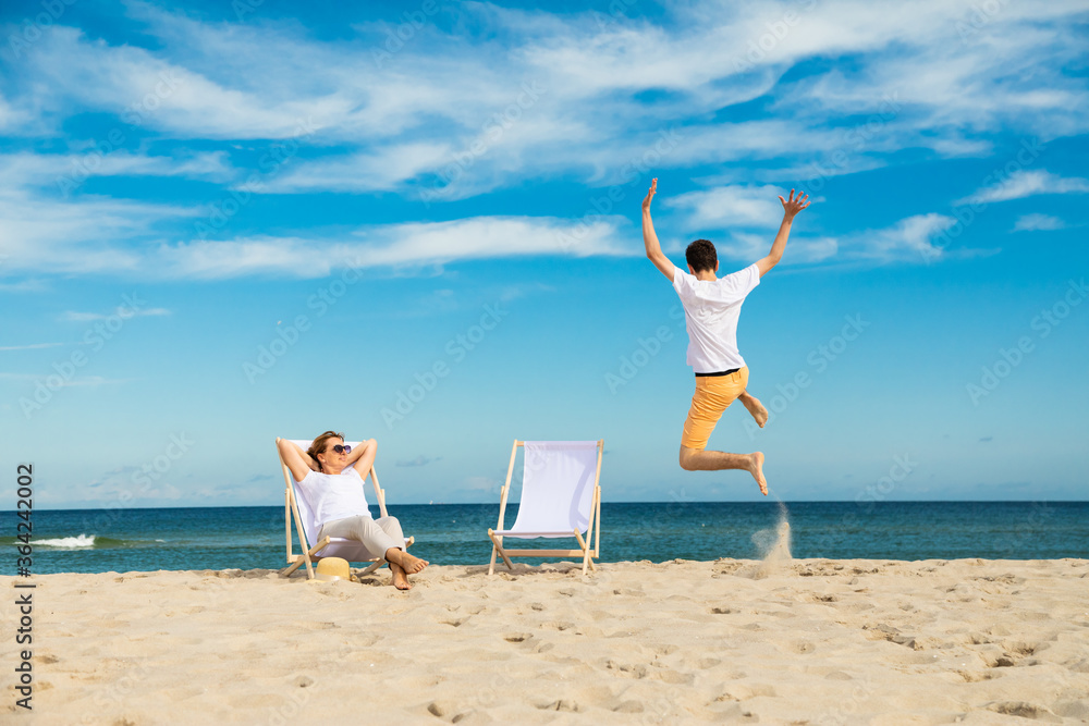 Wall mural Woman and man relaxing on beach
