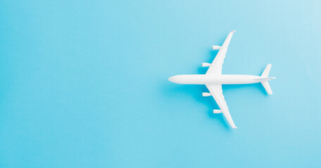World Tourism Day, Top view flat lay of minimal toy model plane, airplane, studio shot isolated on a blue background, accessory flight holiday concept