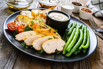 Roast chicken fillets with green beans and fried potatoes  on wooden table
