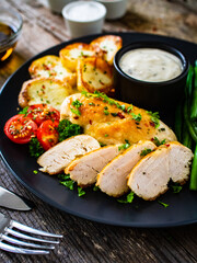 Roast chicken fillets with green beans and fried potatoes  on wooden table
