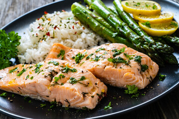 Steamed salmon fillet with basmati rice, asparagus and vegetables on wooden table