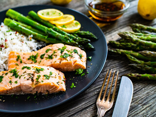 Steamed salmon fillet with basmati rice, asparagus and vegetables on wooden table
