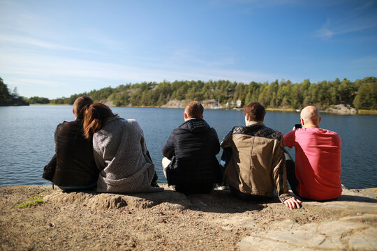 Group of friends standing on rock and   enjoying with beautiful view of Baltic sea in Sweden.