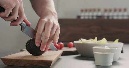 Fototapeta na wymiar man cutting and open avocado in kitchen