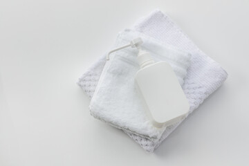白いタオルと消毒液が入ったポンプ/除菌イメージ