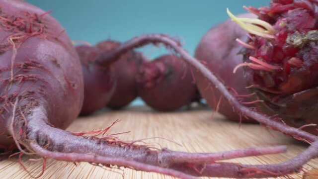 super close up. details. fresh beets on a wooden board on a blue background