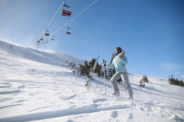 A woman posing with ski in mountain ski resort in  winter season,sunny day