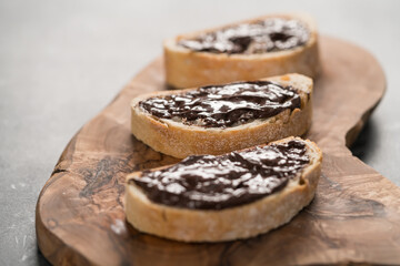 Rustic ciabatta with organic chocolate cream on olive wood board