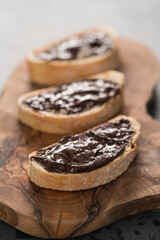 Rustic ciabatta with organic chocolate cream on olive wood board