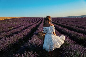 sexy woman with blond hair in elegant clothes with accessories posing in blooming lavender fields