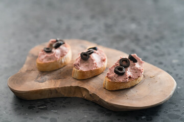 Ciabatta with meat paste on olive wowod board