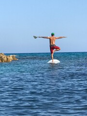 person on a SUP practicing yoga on an ocean