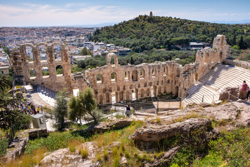 Naklejka premium Panoramic view of Odeon of Herodes Atticus stone Roman theater, Herodeion or Herodion, at slope of Acropolis hill with metropolitan Athens, Greece in background