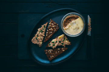 Homemade duck liver foie gras pate in a glass jar with brown bread Delicious food