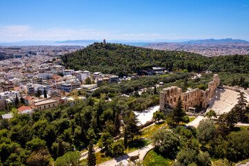 Fototapeta premium Panoramic view of Odeon of Herodes Atticus stone Roman theater, Herodeion or Herodion, at slope of Acropolis hill with metropolitan Athens, Greece in background