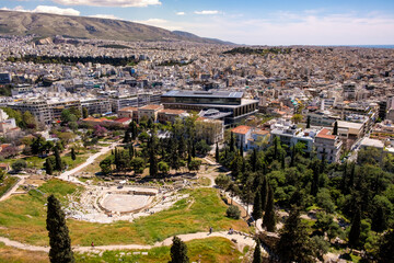 Obraz premium Panoramic view of Theatre of Dionysos ancient Greek theater at slope of Acropolis hill with Acropolis Museum and metropolitan Athens, Greece in background