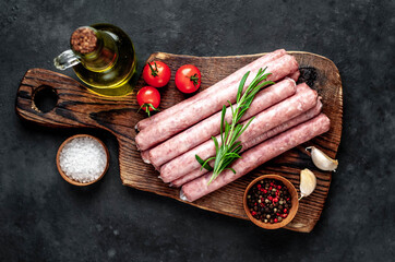 
Thin raw meat sausages on a stone background