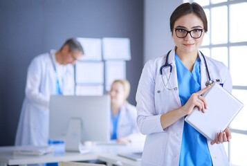 Female doctor using tablet computer in hospital lobby