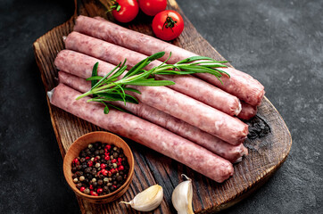 
Thin raw meat sausages on a stone background