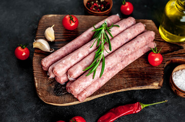 
Thin raw meat sausages on a stone background