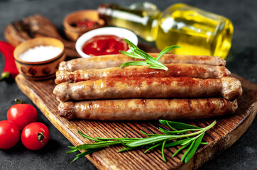 
Thin grilled meat sausages on a stone background