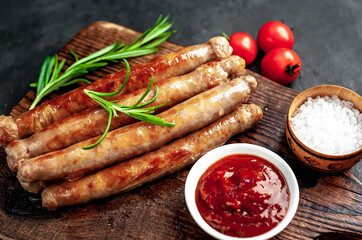 
Thin grilled meat sausages on a stone background