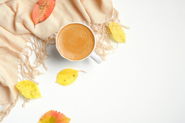 Flat lay autumn composition with cup of coffee, fallen leaves, beige scarf on white background. To view, overhead. Autumn concept.