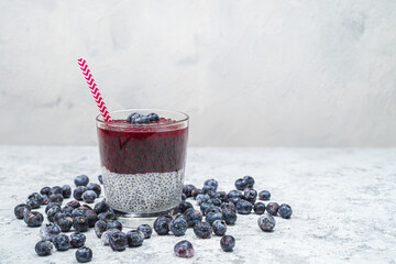 Fototapeta na wymiar Healthy breakfast or morning snack with chia seeds and blueberries on white stone background, vegetarian food, diet and health concept.