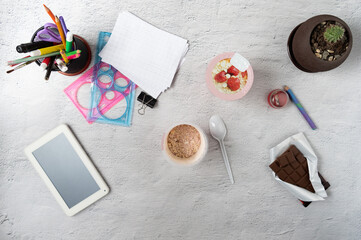 Breakfast at the workplace. Porridge and chocolate on a clerical desk. Flat lay.