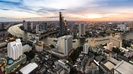 Bangkok city with transportation along the Chao Phraya river at Dusk. Sunset at modern business building at district area.