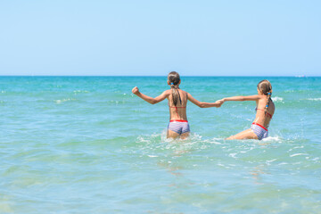 Two girls swim in the sea on a hot day
