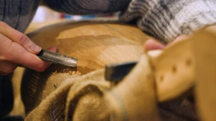 Wooden workwhop. A man carves a wood. The carpenter works in a studio. An engineer provides a tree shape. An engineer provides a tree shape. Creating wooden masterpiece. Carpenter with chisel - Powered by Adobe