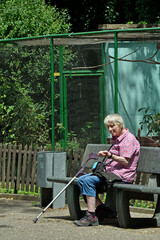 seniorin sitzt auf einer bank