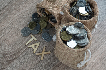 Tax concept with coins. Tax latter with coins on wooden table