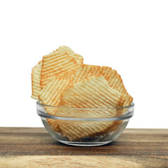 Corrugated potato chips on a wooden board. Snack, junk food. Close up.