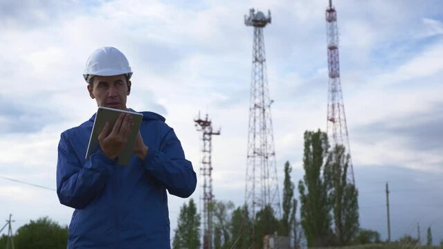 A telecommunications engineer working on a digital tablet records data for maintenance of the telecommunications network. Design, repair and installation of satellite and telecommunications networks.