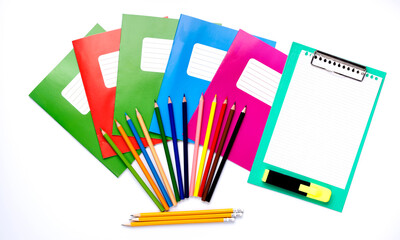 Colorful school exercise books and drawing pencils on white background.
