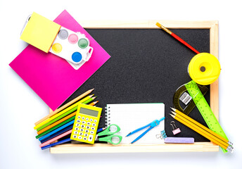 Many different school supplies on blackboard copy space background. Back to school concept.