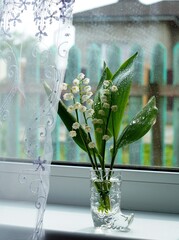 a bouquet of lily of the valley flowers in a vase on the window