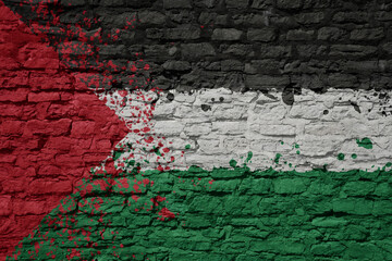 painted big national flag of palestine on a massive old brick wall