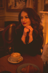 Smiling woman drinking coffee in cozy cafe closeup. Good morning. Selective focus.