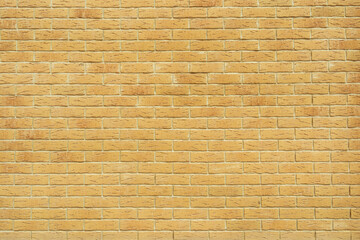 yellow brick wall background. masonry consists of notched bricks. Panoramic background of wide Brick wall detail texture.