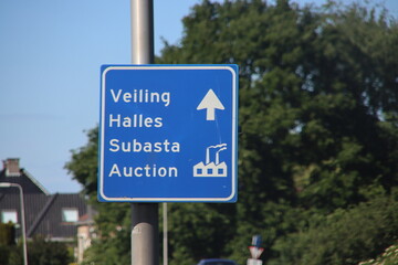 Direction sign in Blue and white heading the flower auction in Bleiswijk the Netherlands.