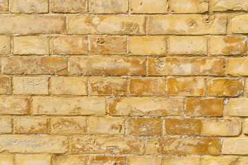 Grunge dirty vintage yellow brick wall texture background.