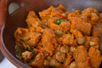  Javanese spicy stew of cattle skin crackers (krecek). typical side dish for gudeg. served in a traditional earthenware wok