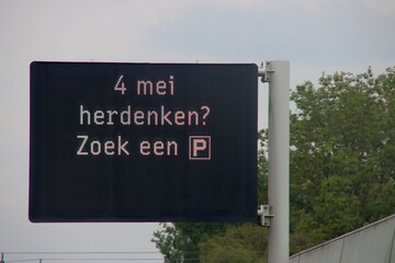 Dynamic information panel above motorway A13 with text to do the rememberance day silence at Parking lot